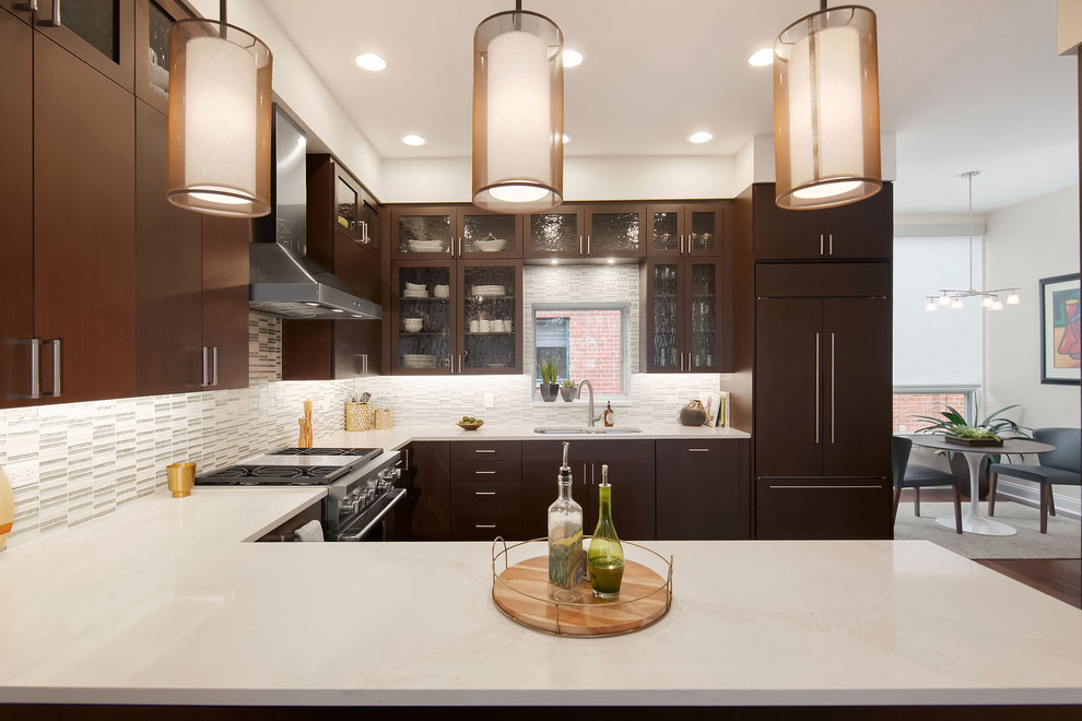 Inspiration for a large contemporary u-shaped kitchen in Chicago with a double-bowl sink, flat-panel cabinets, dark wood cabinets, multi-coloured splashback, glass tile splashback, dark hardwood floors, a peninsula, brown floor, quartzite benchtops and stainless steel appliances.