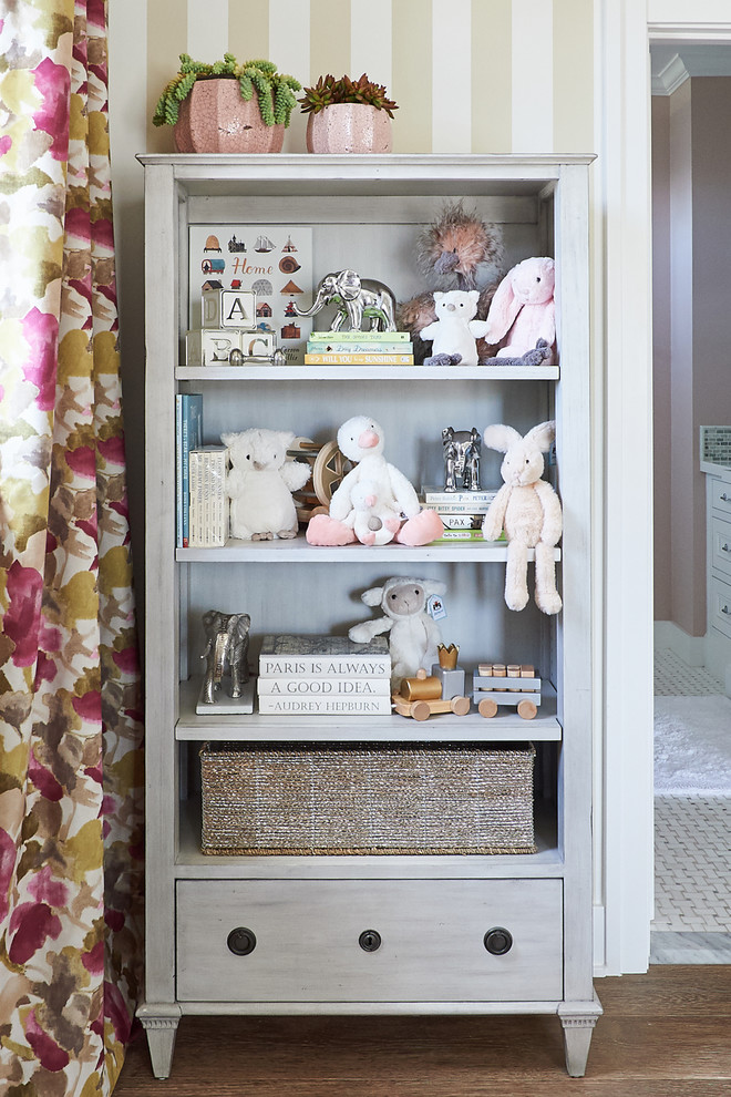 Design ideas for a large transitional nursery for girls in San Diego with multi-coloured walls and light hardwood floors.