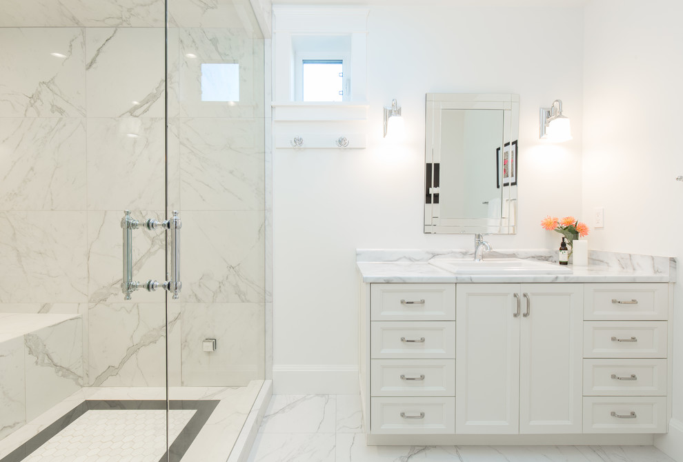 Mid-sized traditional bathroom in Vancouver with recessed-panel cabinets, white cabinets, an alcove shower, marble, white walls, marble floors, a drop-in sink, marble benchtops, a hinged shower door, white tile, white floor and white benchtops.