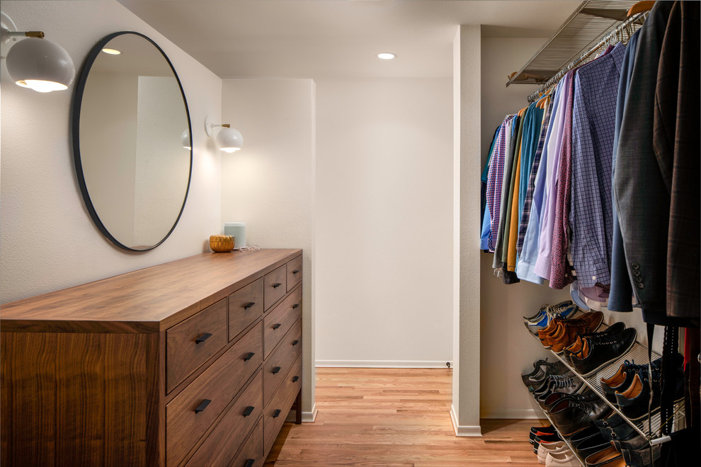 Inspiration for a mid-sized midcentury men's walk-in wardrobe in Portland with flat-panel cabinets, dark wood cabinets and medium hardwood floors.