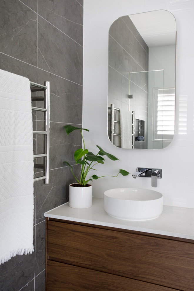 Inspiration for a mid-sized contemporary bathroom in Brisbane with medium wood cabinets, gray tile, porcelain tile, grey walls, porcelain floors, a vessel sink, engineered quartz benchtops, white benchtops, a single vanity and a floating vanity.