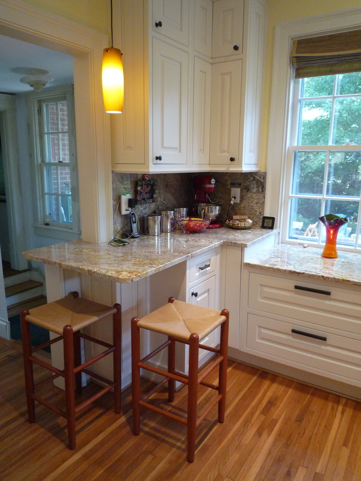 Enclosed kitchen - mid-sized transitional l-shaped medium tone wood floor and brown floor enclosed kitchen idea with no island, raised-panel cabinets, white cabinets, granite countertops, multicolored backsplash, stone slab backsplash, stainless steel appliances and an undermount sink