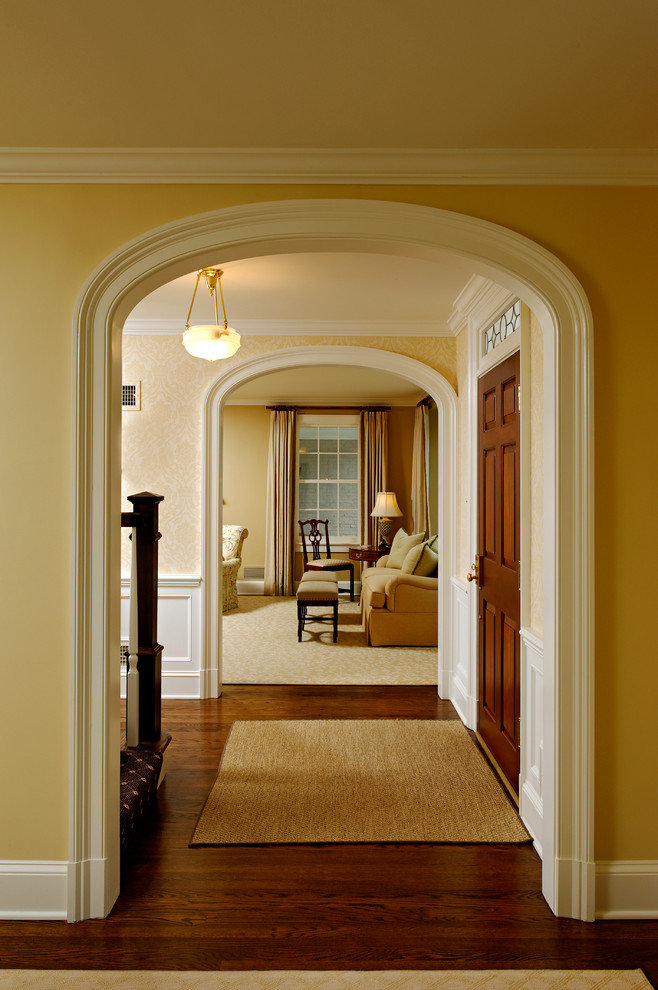 Traditional entryway in DC Metro with beige walls, dark hardwood floors and a single front door.