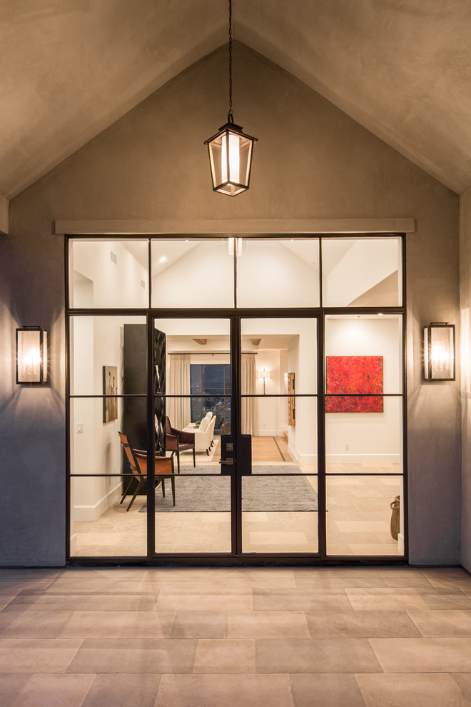 Photo of an expansive transitional foyer in Orange County with white walls, limestone floors, a double front door and a metal front door.