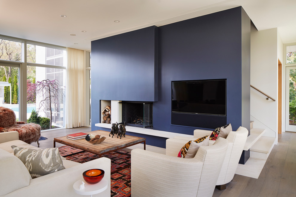 This is an example of a contemporary living room in Chicago with blue walls, dark hardwood floors and a standard fireplace.