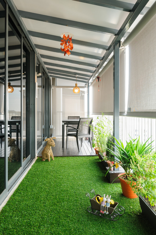 Inspiration for a small contemporary balcony in Singapore with a container garden and an awning.