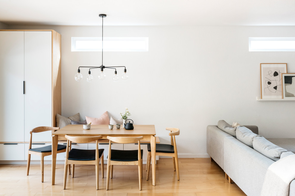 Inspiration for a small scandi open plan dining room in San Francisco with white walls, light hardwood flooring, no fireplace and brown floors.