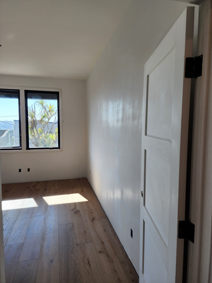 Inspiration for a large modern guest vinyl floor and brown floor bedroom remodel in San Francisco with multicolored walls