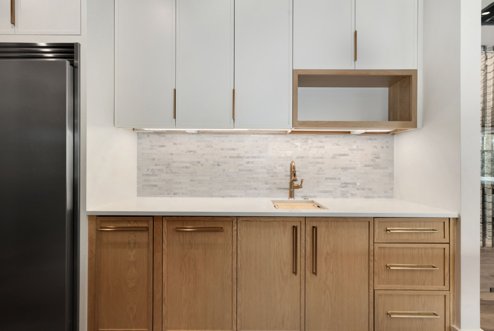 Kitchen - large kitchen idea with light wood cabinets, white backsplash, stone slab backsplash, stainless steel appliances, two islands and white countertops