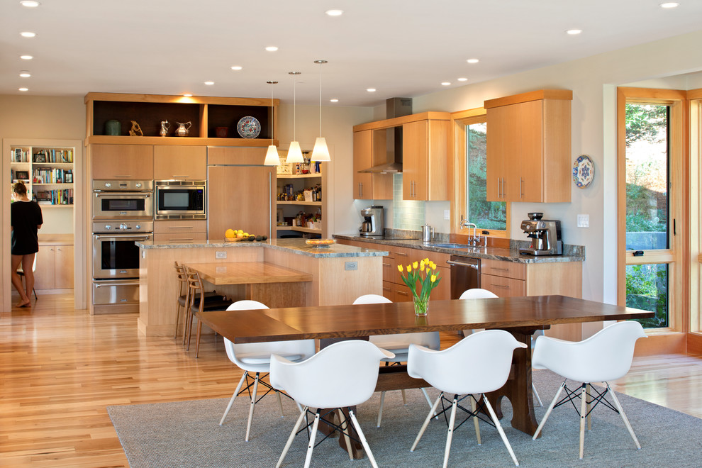 Photo of a contemporary eat-in kitchen in San Francisco with an undermount sink, flat-panel cabinets, light wood cabinets, panelled appliances, light hardwood floors, beige floor and grey benchtop.