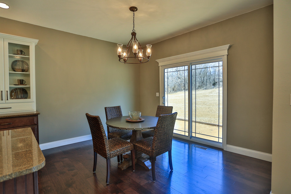 This is an example of a transitional open plan dining in St Louis with grey walls and dark hardwood floors.