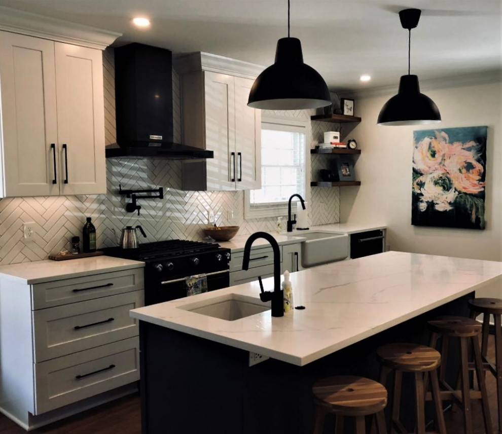 Large transitional galley dark wood floor and brown floor eat-in kitchen photo with a farmhouse sink, shaker cabinets, white cabinets, quartzite countertops, white backsplash, subway tile backsplash, black appliances, an island and white countertops