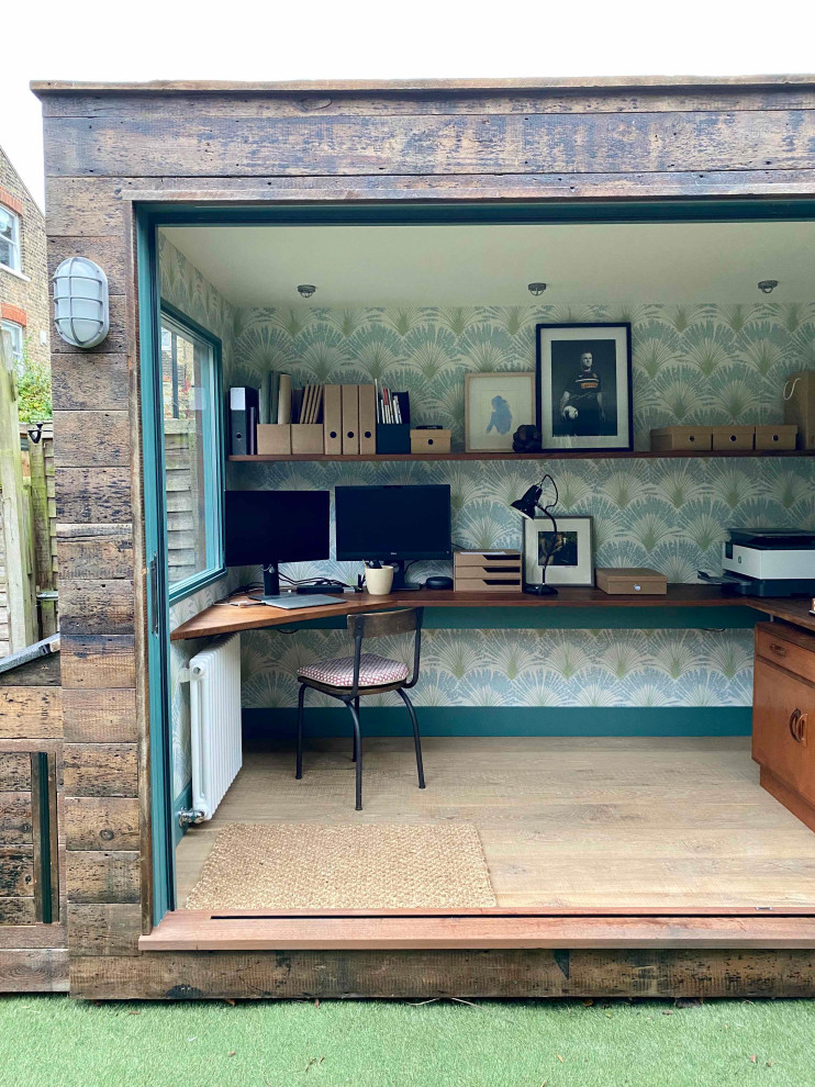 Immagine di un piccolo ufficio stile rurale con pareti blu, parquet chiaro, nessun camino, scrivania incassata, pavimento beige e carta da parati