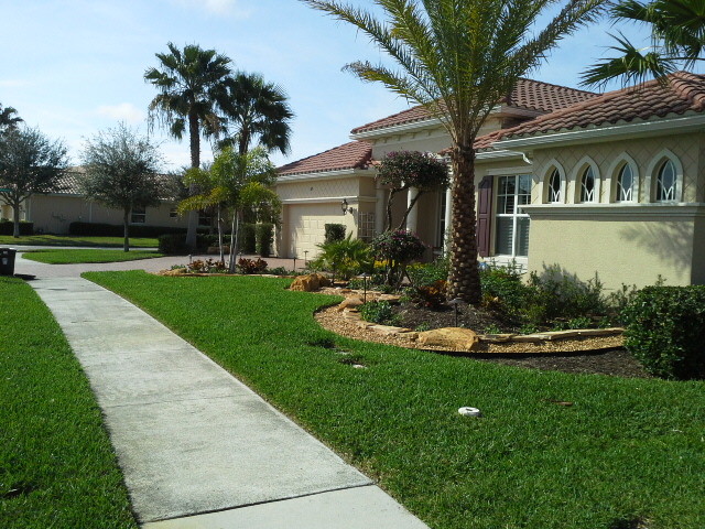 Mid-sized tropical front yard full sun driveway in Tampa with brick pavers.