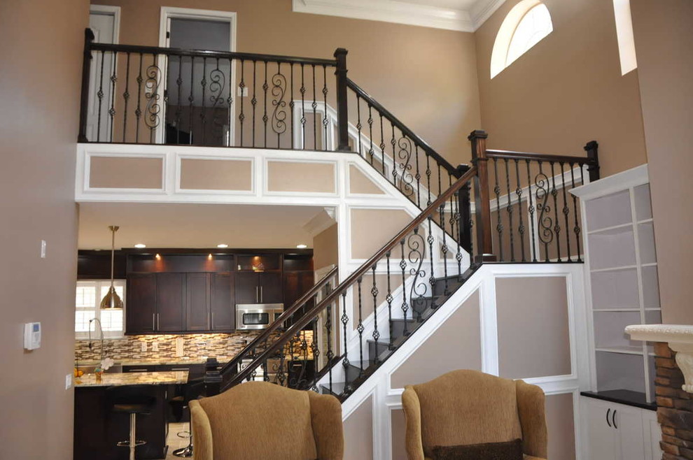 This is an example of a large arts and crafts wood u-shaped staircase in Tampa with wood risers.