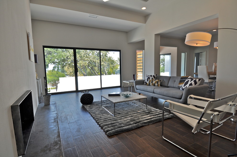 This is an example of a medium sized contemporary living room in Austin with white walls and a metal fireplace surround.