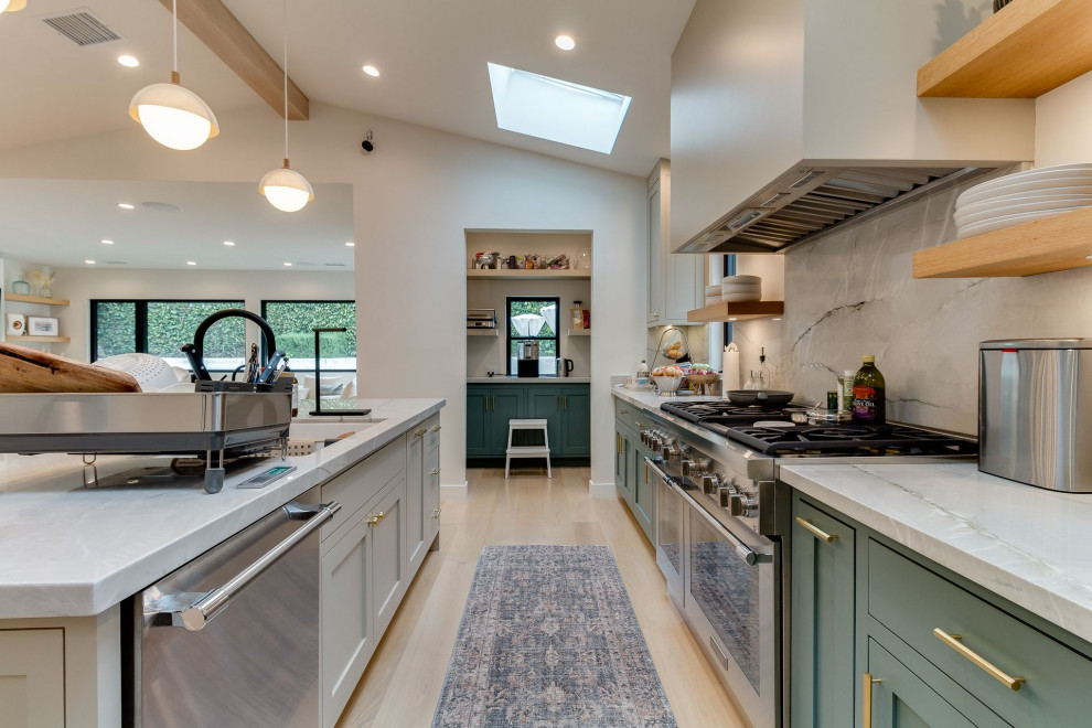 Inspiration for a l-shaped light wood floor and exposed beam eat-in kitchen remodel in Los Angeles with an undermount sink, shaker cabinets, green cabinets, quartzite countertops, gray backsplash, stone slab backsplash, stainless steel appliances, an island and gray countertops