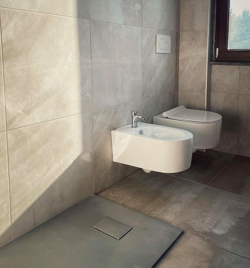 Photo of a small powder room in Milan with a wall-mount toilet, beige tile, porcelain tile, porcelain floors and brown floor.