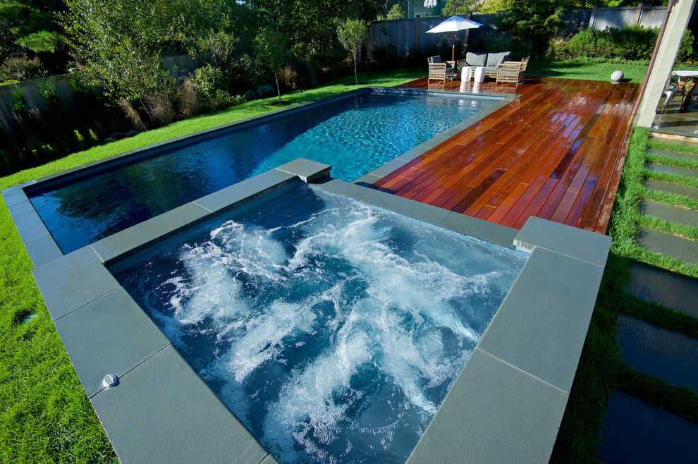 Mid-sized contemporary side yard rectangular pool in Philadelphia with a hot tub and decking.