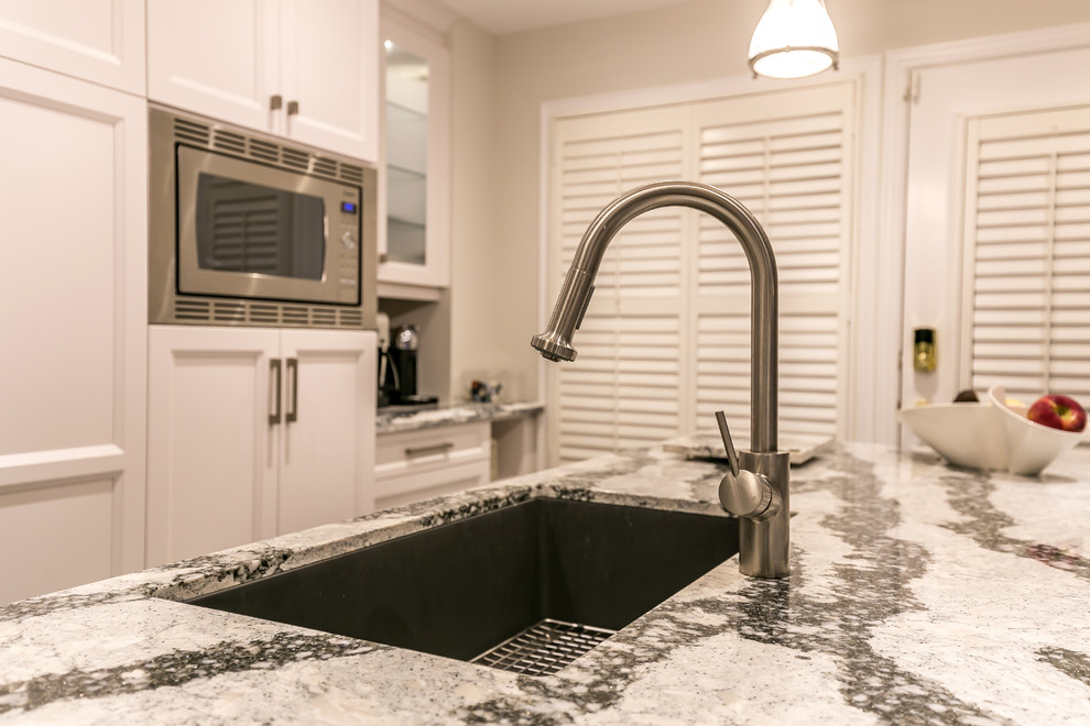 Enclosed kitchen - large transitional gray floor enclosed kitchen idea in Toronto with an undermount sink, recessed-panel cabinets, white cabinets, quartz countertops, white backsplash, ceramic backsplash, stainless steel appliances and an island