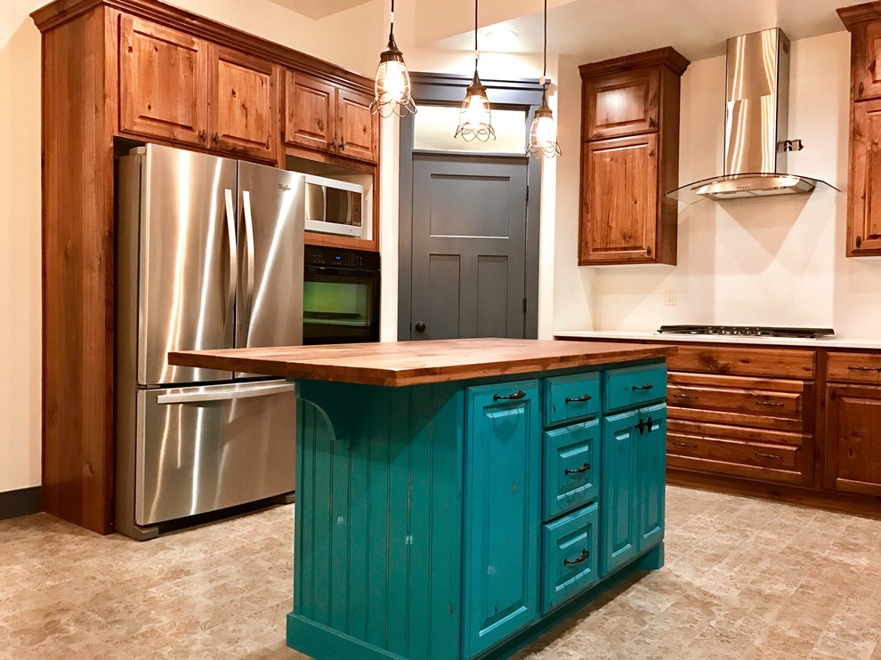 Design ideas for a mid-sized traditional l-shaped eat-in kitchen in Salt Lake City with raised-panel cabinets, medium wood cabinets, wood benchtops, beige splashback, stainless steel appliances, ceramic floors and with island.
