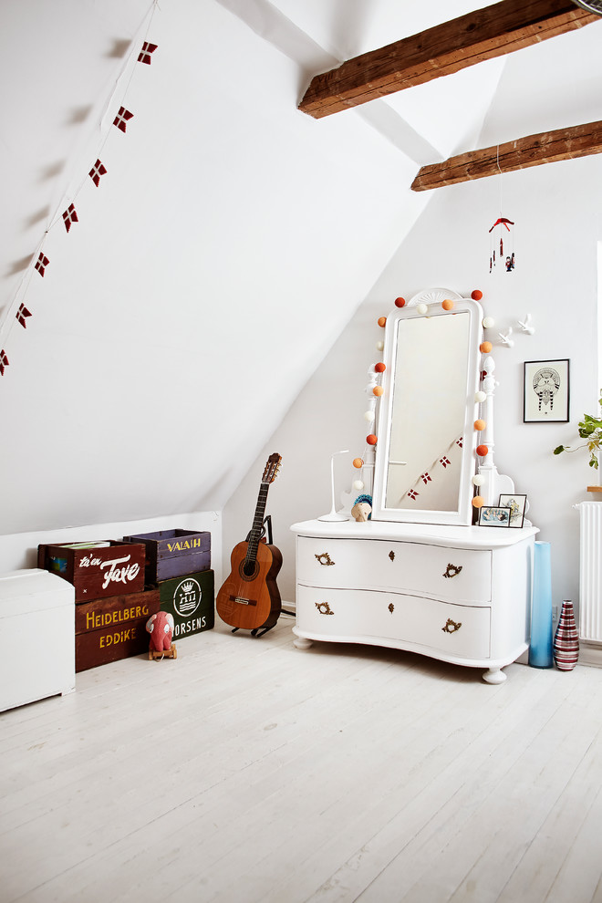Photo of a large scandinavian gender-neutral kids' playroom for kids 4-10 years old in Aarhus with white walls, light hardwood floors and white floor.