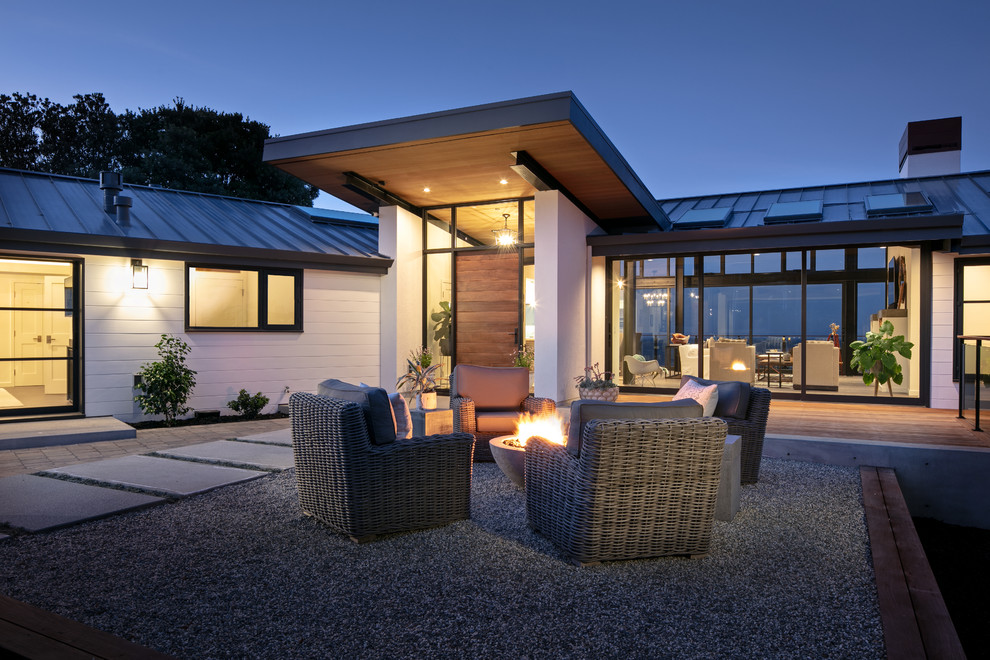 Contemporary front yard patio in Other with a fire feature, gravel and no cover.