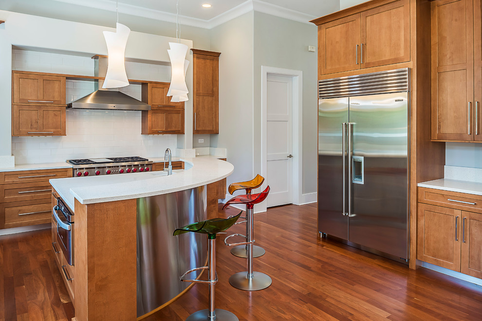 Eat-in kitchen - large transitional u-shaped medium tone wood floor eat-in kitchen idea in Chicago with an undermount sink, recessed-panel cabinets, medium tone wood cabinets, terrazzo countertops, white backsplash, stainless steel appliances and an island