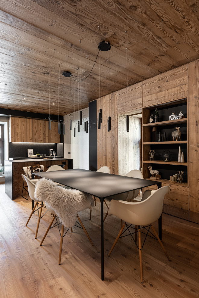 Immagine di una piccola sala da pranzo aperta verso la cucina rustica con pareti marroni, parquet scuro, pavimento marrone, soffitto in legno e pareti in legno