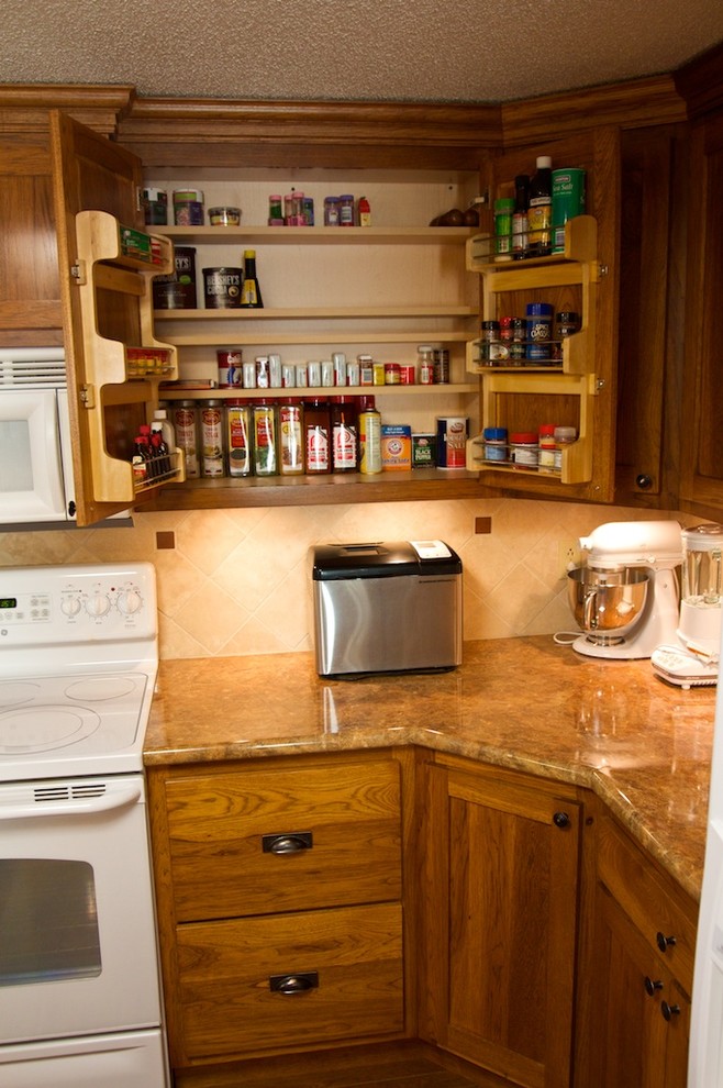 Eat-in kitchen - mid-sized u-shaped eat-in kitchen idea with raised-panel cabinets, medium tone wood cabinets, laminate countertops, beige backsplash, stone tile backsplash, white appliances and an island