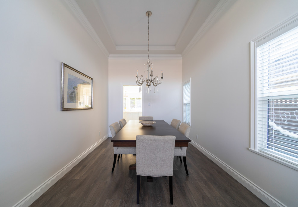 Inspiration for a traditional separate dining room in Vancouver with white walls, medium hardwood floors and brown floor.