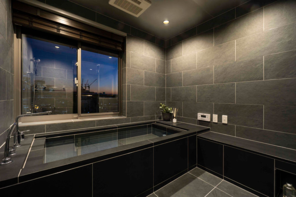 Foto de cuarto de baño doble y flotante moderno con jacuzzi, baldosas y/o azulejos negros, paredes negras, lavabo bajoencimera, suelo negro y bandeja