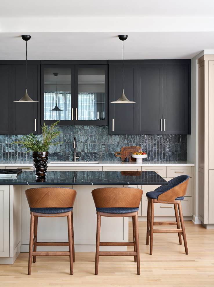 Open concept kitchen - mid-sized transitional galley light wood floor and brown floor open concept kitchen idea in Chicago with an undermount sink, recessed-panel cabinets, brown cabinets, quartz countertops, gray backsplash, ceramic backsplash, paneled appliances, an island and black countertops