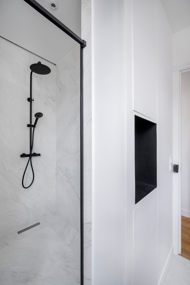 This is an example of a mid-sized contemporary 3/4 bathroom in Paris with open cabinets, black cabinets, a curbless shower, a wall-mount toilet, white tile, marble, white walls, marble floors, a vessel sink, marble benchtops, white floor, a sliding shower screen, white benchtops, a niche, a single vanity and a built-in vanity.