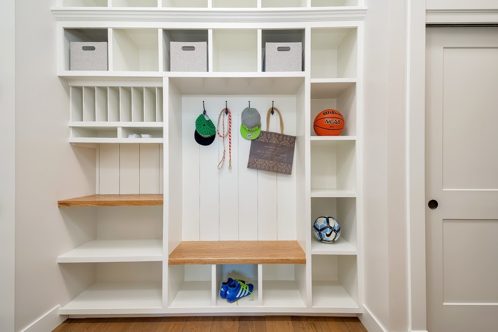 Inspiration for a mid-sized contemporary mudroom in Boise with white walls, medium hardwood floors and brown floor.