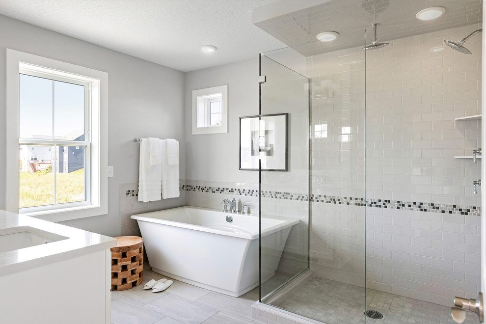 Large transitional master bathroom in Minneapolis with shaker cabinets, white cabinets, a freestanding tub, a corner shower, gray tile, ceramic tile, grey walls, cement tiles, an undermount sink, granite benchtops, grey floor, a hinged shower door and white benchtops.