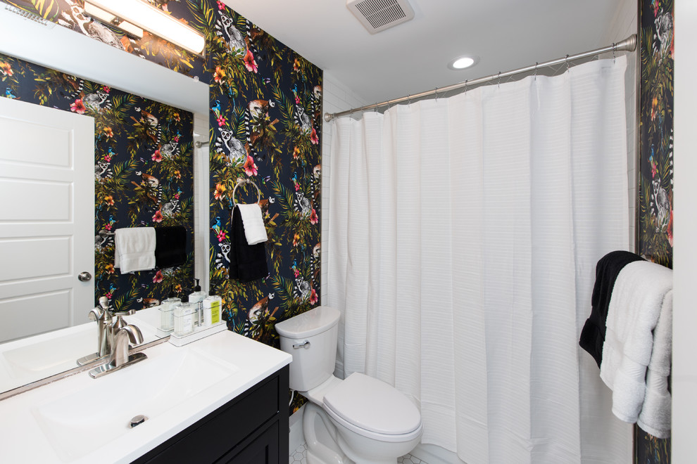 Inspiration for a mid-sized midcentury 3/4 bathroom in Baltimore with recessed-panel cabinets, black cabinets, an alcove tub, a shower/bathtub combo, a two-piece toilet, multi-coloured walls, ceramic floors, an integrated sink, solid surface benchtops, white floor, a shower curtain and white benchtops.