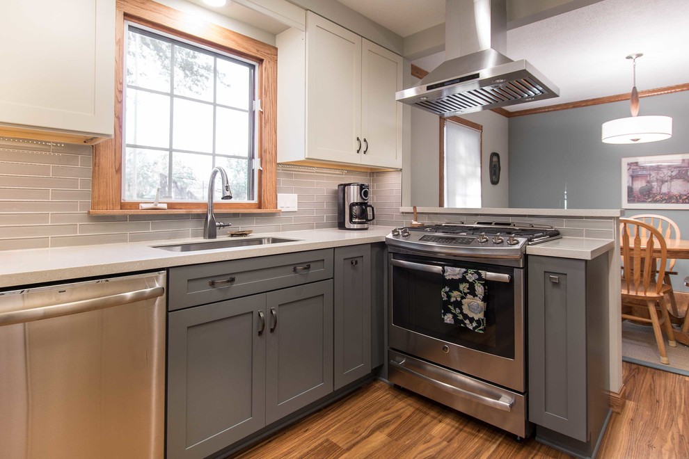 Eat-in kitchen - small transitional galley vinyl floor and brown floor eat-in kitchen idea with recessed-panel cabinets, white cabinets, gray backsplash and stainless steel appliances