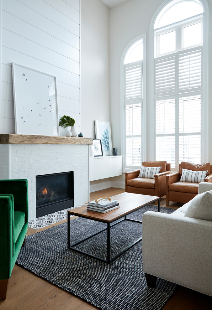 Inspiration for a transitional light wood floor living room remodel in Toronto with beige walls, a standard fireplace and a brick fireplace
