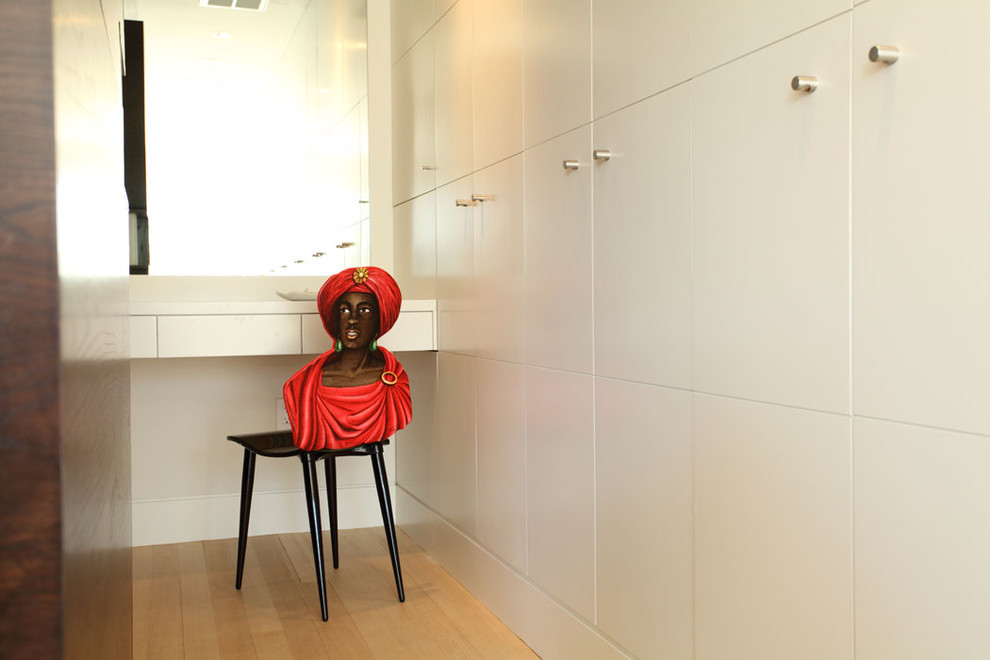 Contemporary storage and wardrobe in Boston with flat-panel cabinets and white cabinets.