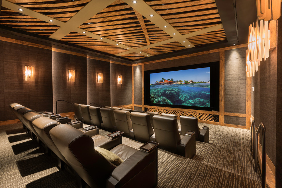 Inspiration for a tropical enclosed home theatre in Hawaii with brown walls, carpet and grey floor.