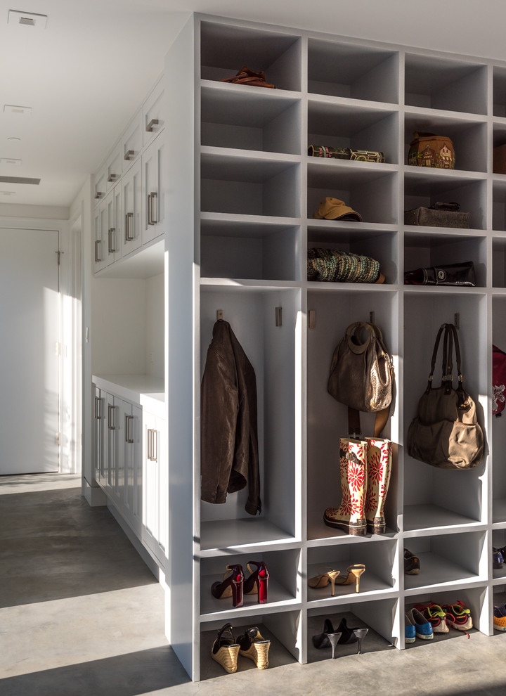 Photo of a large transitional mudroom in San Francisco with white walls and concrete floors.