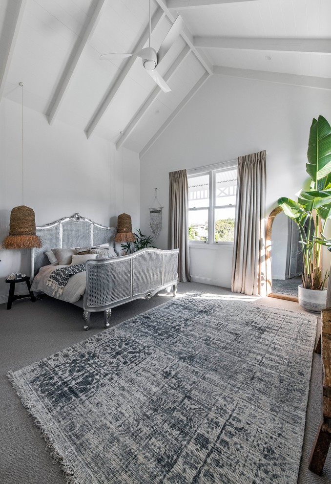 Photo of a large beach style master bedroom in Brisbane with white walls, carpet and grey floor.
