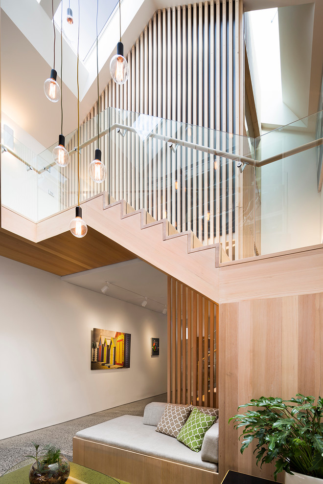 This is an example of a mid-sized contemporary open concept living room in Melbourne with white walls and concrete floors.