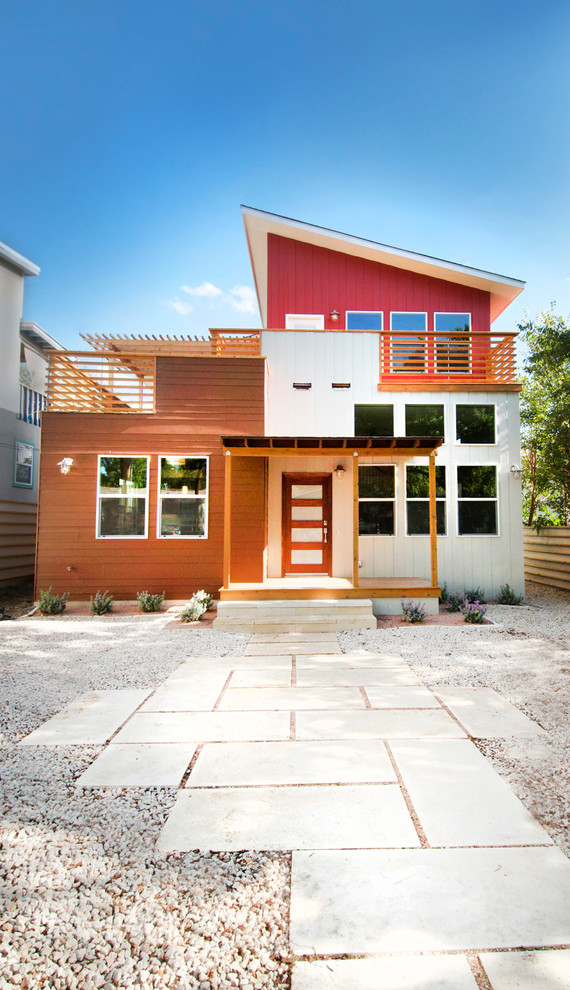 Transitional two-storey exterior in Austin with mixed siding.