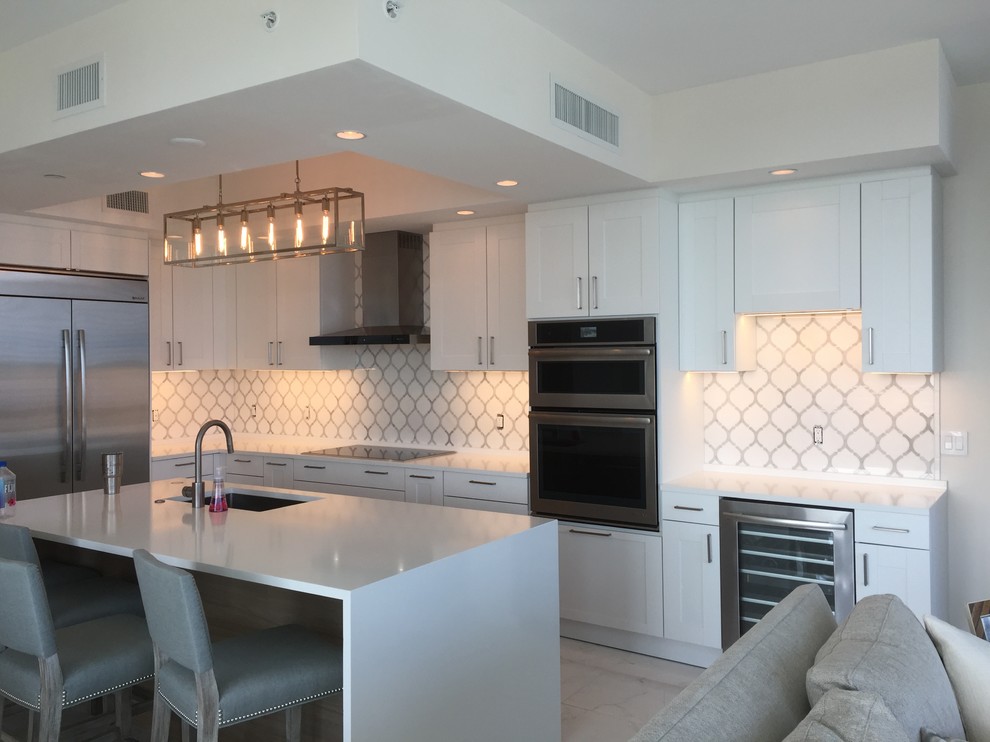 Large trendy single-wall enclosed kitchen photo with a double-bowl sink, marble backsplash and stainless steel appliances