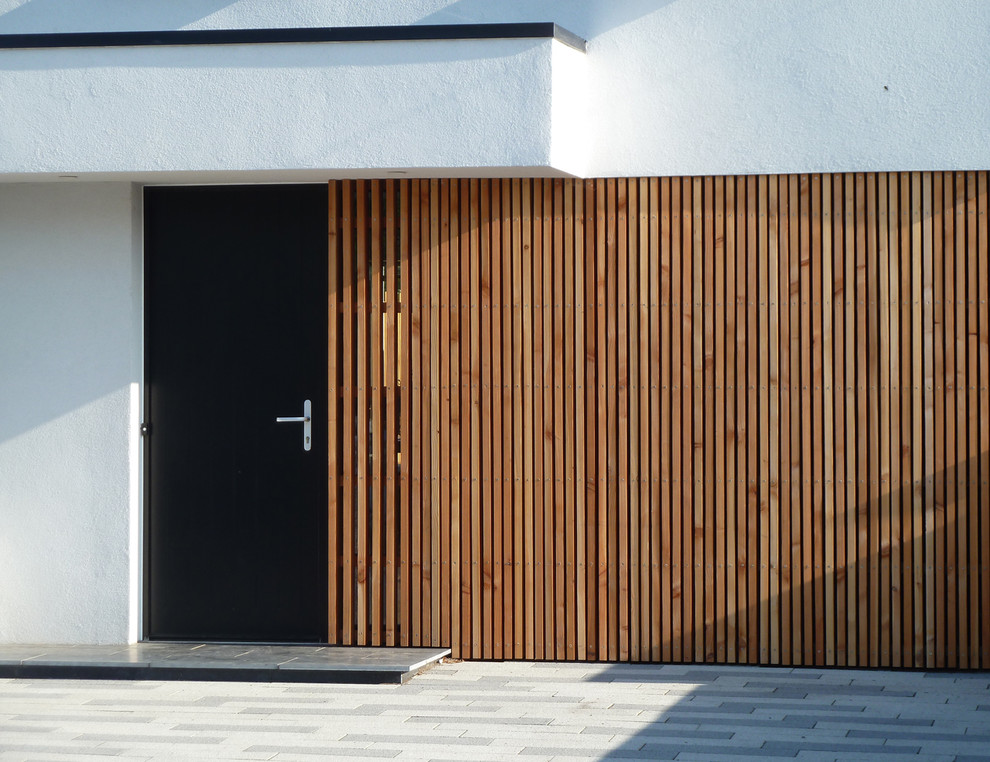 Photo of a mid-sized contemporary two-storey exterior in Cork with wood siding.