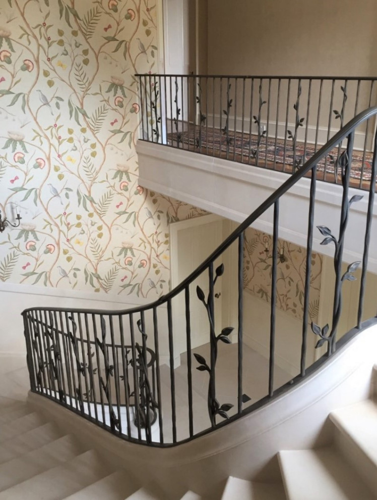 Imagen de escalera curva campestre grande con barandilla de metal y papel pintado