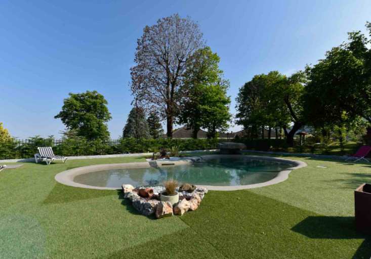 This is an example of a mid-sized contemporary courtyard custom-shaped natural pool in Turin with a hot tub.