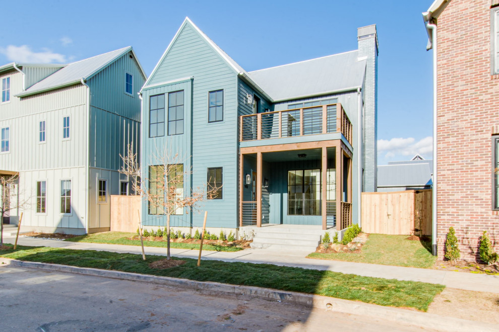 Mittelgroßes, Dreistöckiges Country Einfamilienhaus mit Faserzement-Fassade, blauer Fassadenfarbe, Satteldach, Blechdach, grauem Dach und Wandpaneelen in Oklahoma City